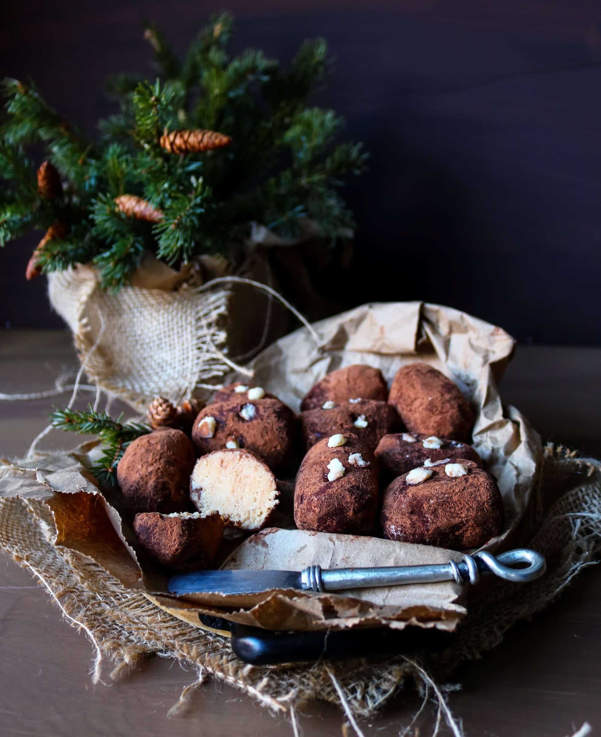 No-bake mini “Potatoes” cakes on parchment paper, showing white cookie filling inside.