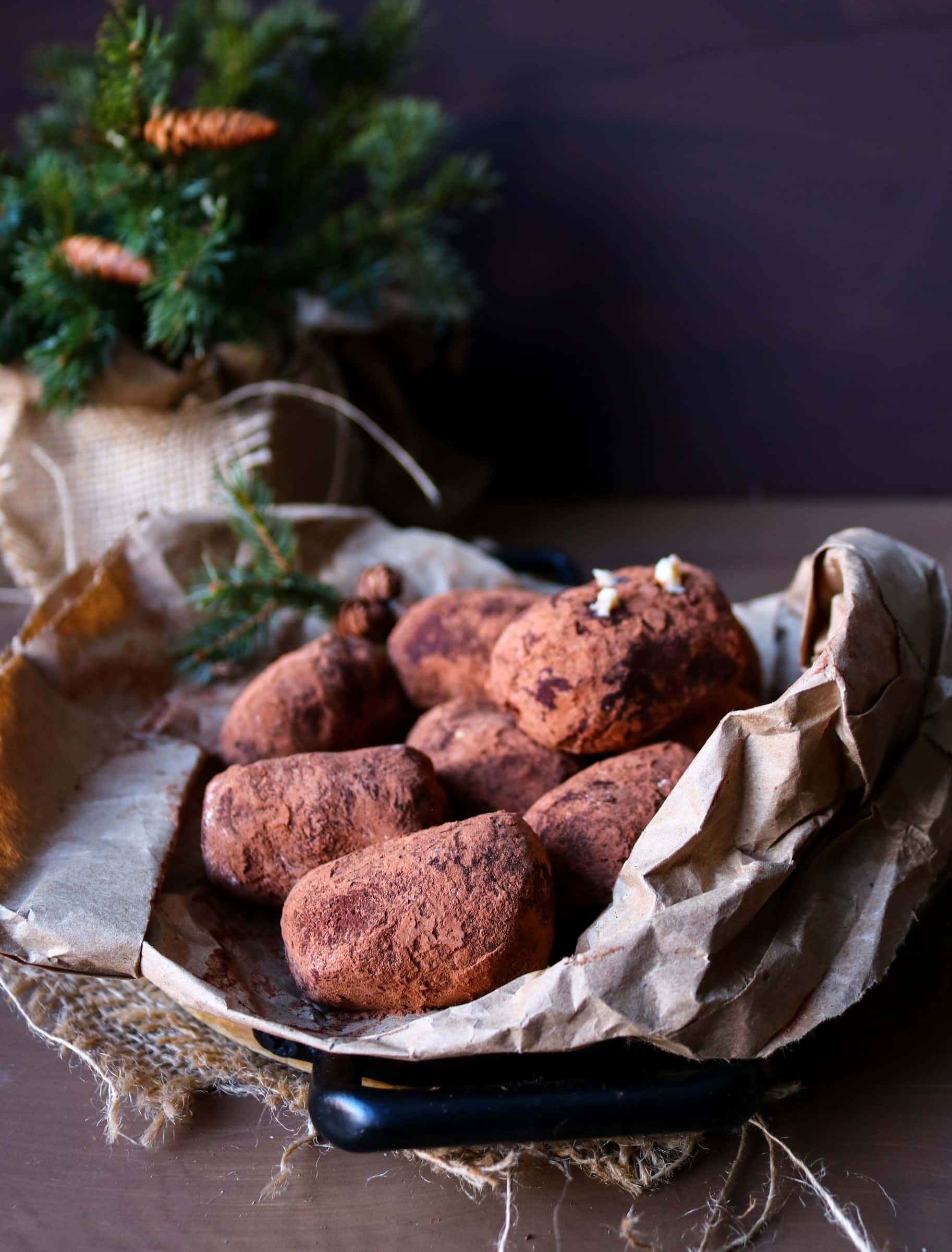 Mini “Potatoes” cakes coated in cocoa powder, arranged on parchment paper with rustic styling.