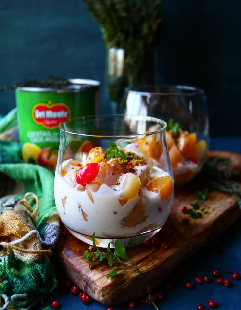 Easy fruit dessert with mascarpone cream, canned fruit cocktail, and orange garnish.