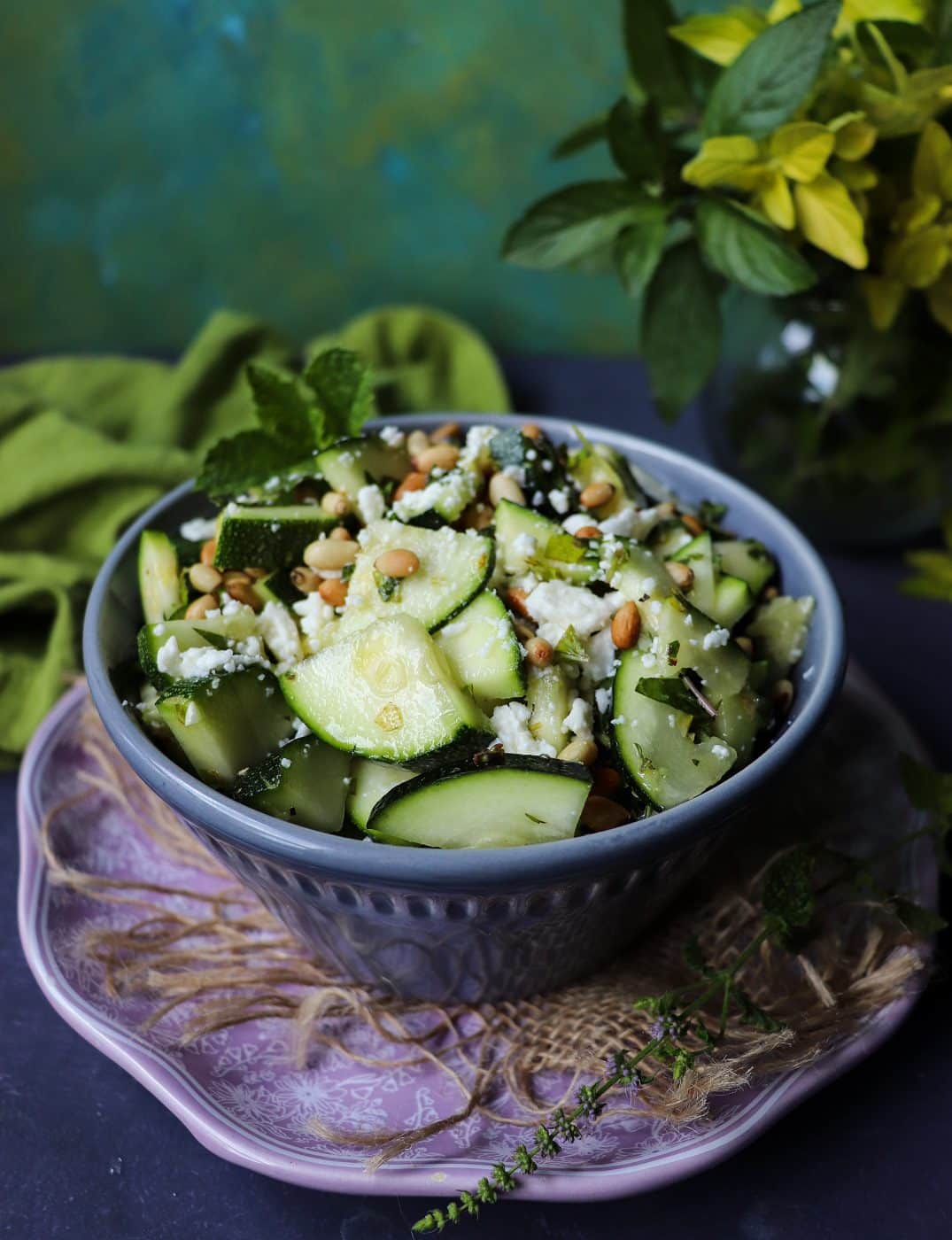 Healthy zucchini salad with feta and pine nuts served in a bowl.