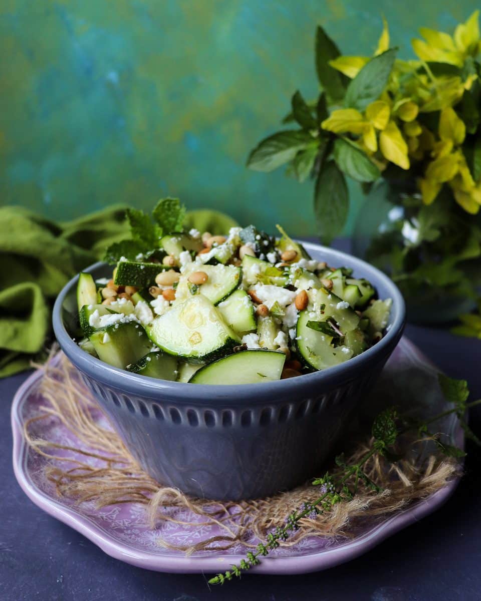 Fresh zucchini salad with feta cheese, herbs, and pine nuts.