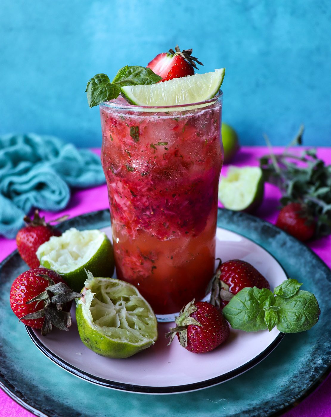 Fresh strawberry mojito cocktail with mint leaves, lime wedges, and crushed ice – a refreshing summer drink.