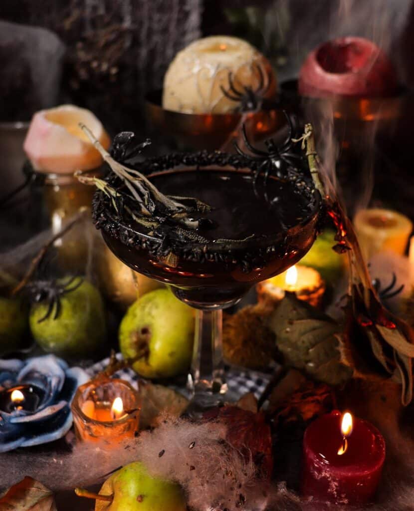 Black Widow Cocktail in a glass with black sesame syrup, rum, and blackberry liqueur — dark Halloween drink with rich colour and moody styling.