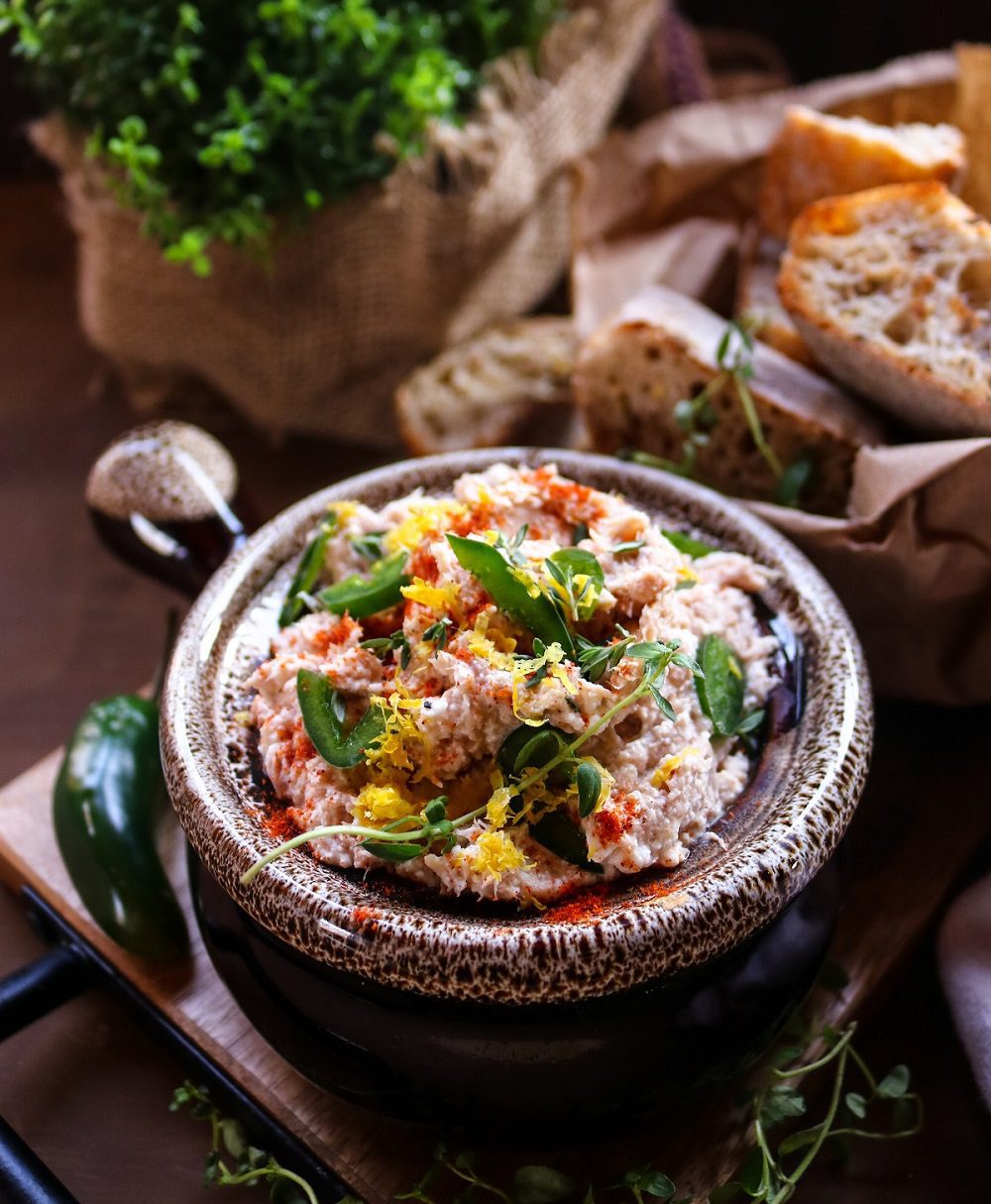 Creamy Tuna Dip with ricotta, lemon zest, fresh herbs, and smoked paprika, served in a rustic bowl with crusty bread on the side.