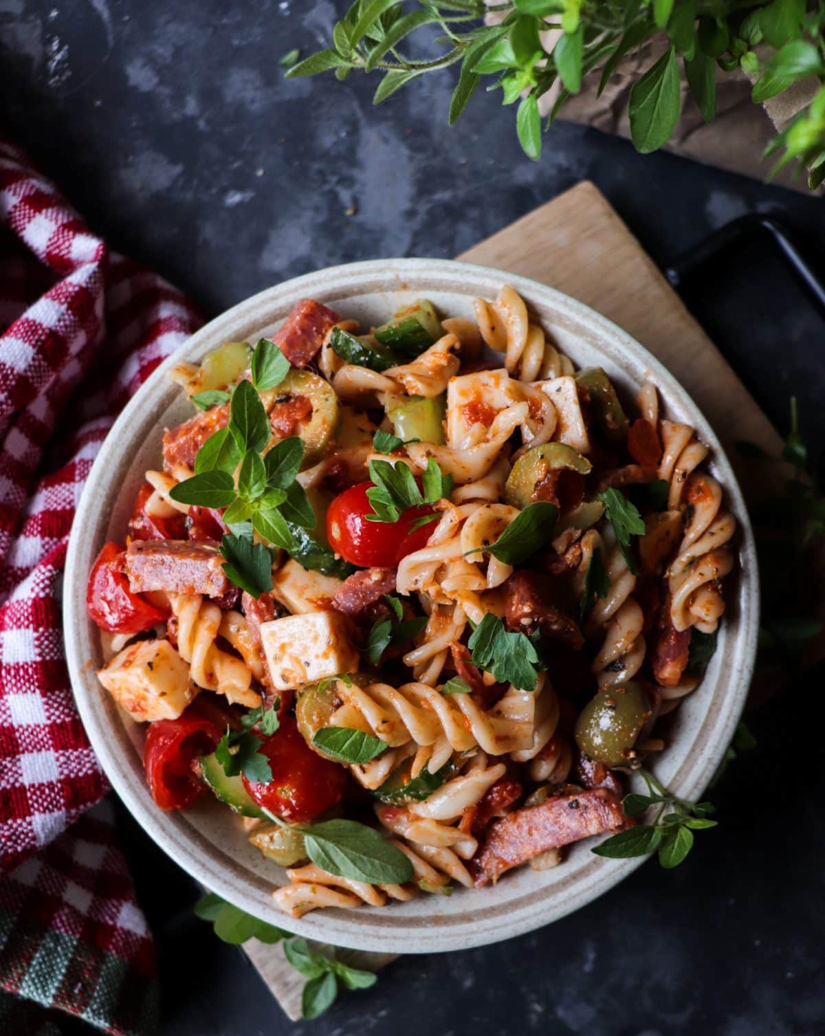 Pasta salad with salami, mozzarella, cherry tomatoes, cucumber, olives, and sun-dried tomatoes tossed in a light Mediterranean dressing.