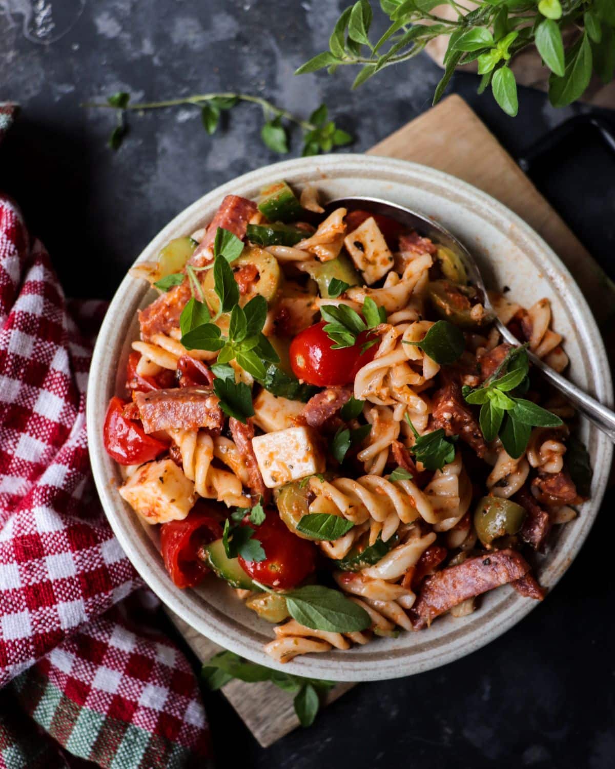Pasta salad with salami, mozzarella, cherry tomatoes, cucumber, olives, and sun-dried tomatoes tossed in a light Mediterranean dressing.