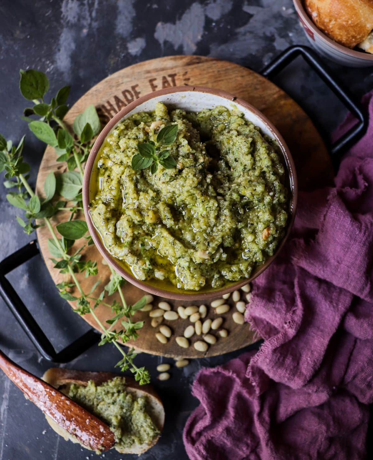 Oregano pesto with Parmesan and pine nuts served in a bowl, drizzled with olive oil and styled with fresh oregano sprigs and rustic bread.