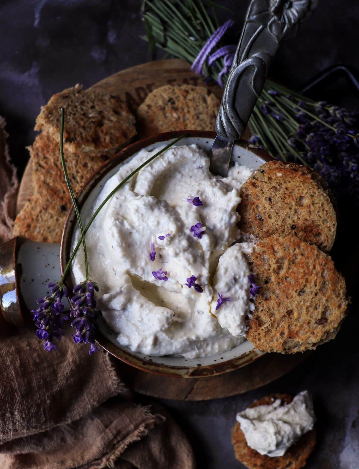 Feta dip with lavender served with crackers, showing thick, spreadable texture and rustic presentation