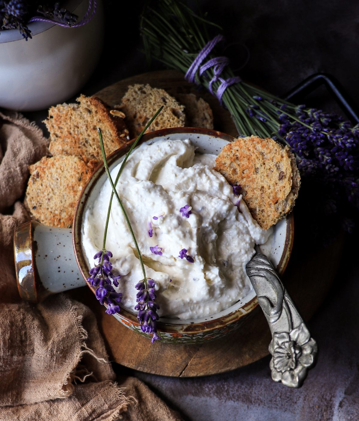 Feta dip with lavender served with crackers, showing thick, spreadable texture and rustic presentation