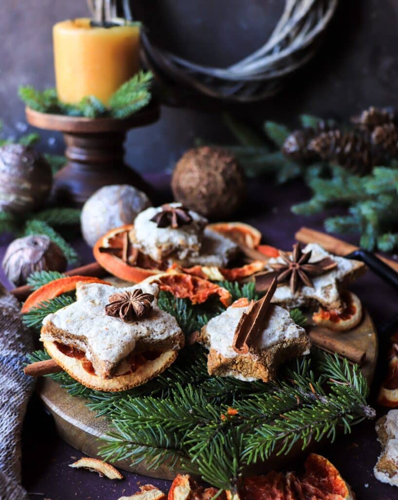 Cozy Christmas composition with Orange Almond Gingerbread Cookies, candlelight, and rustic winter décor creating a warm festive atmosphere.