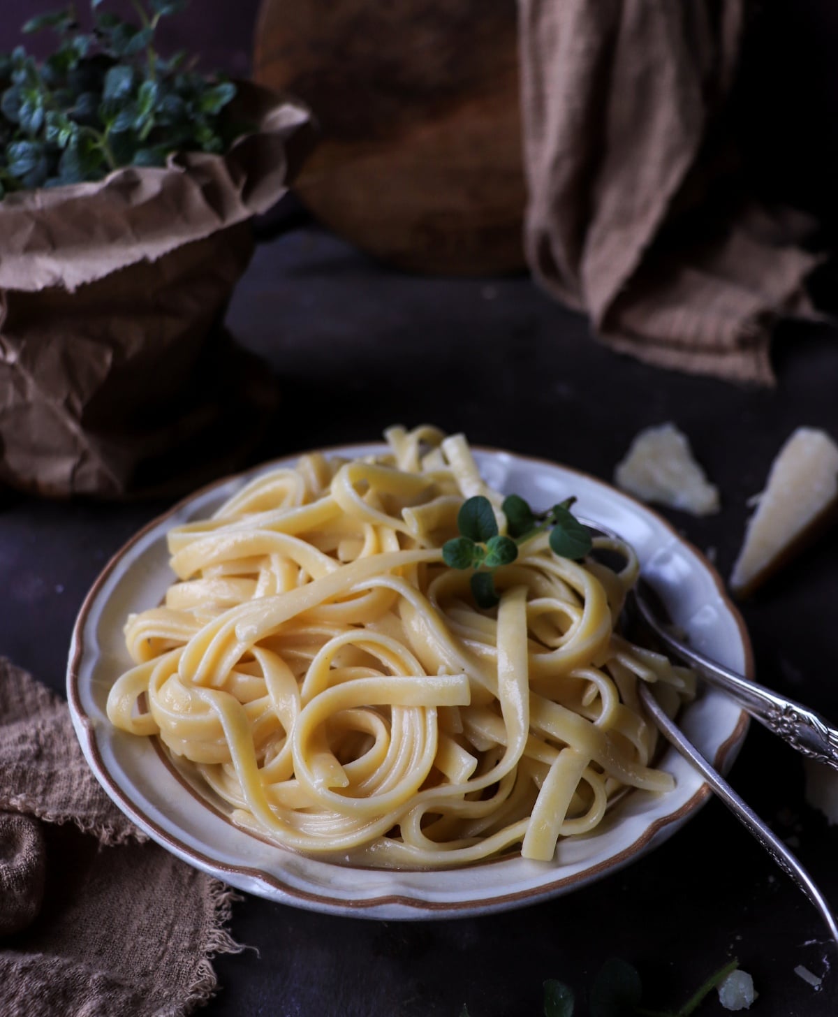 Authentic Italian butter pasta (pasta al burro) made with fettuccine, butter, and Parmigiano Reggiano, served in a white bowl with a fork and finished with a light, glossy coating.