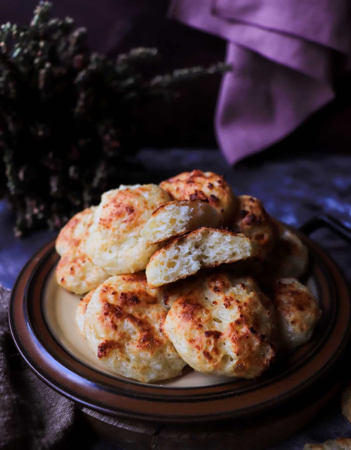 Baked cottage cheese biscuits with one broken open to reveal a soft, chewy, airy interior and tender crumb.
