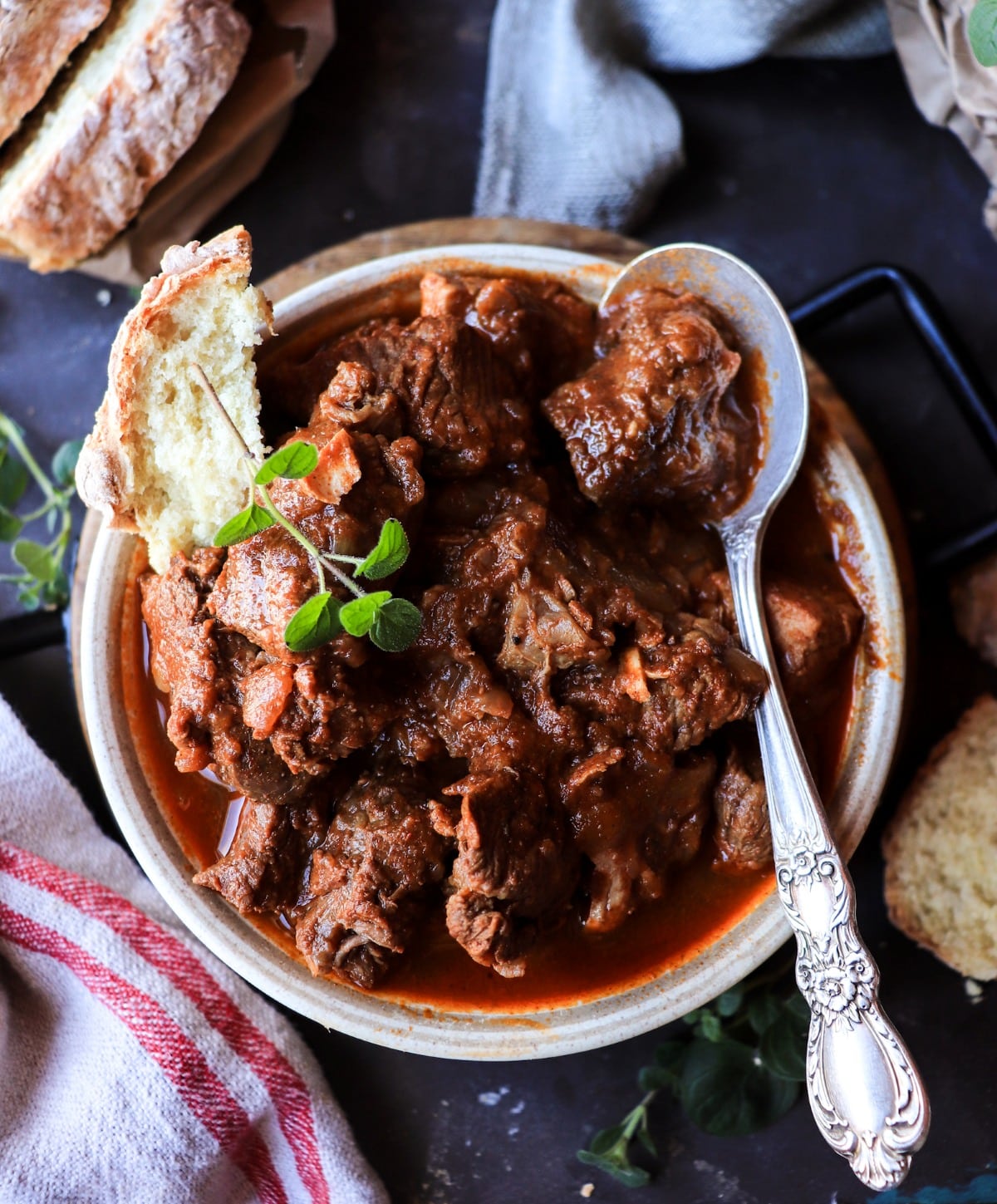 Croatian meat stew served in a bowl with rustic bread for dipping.