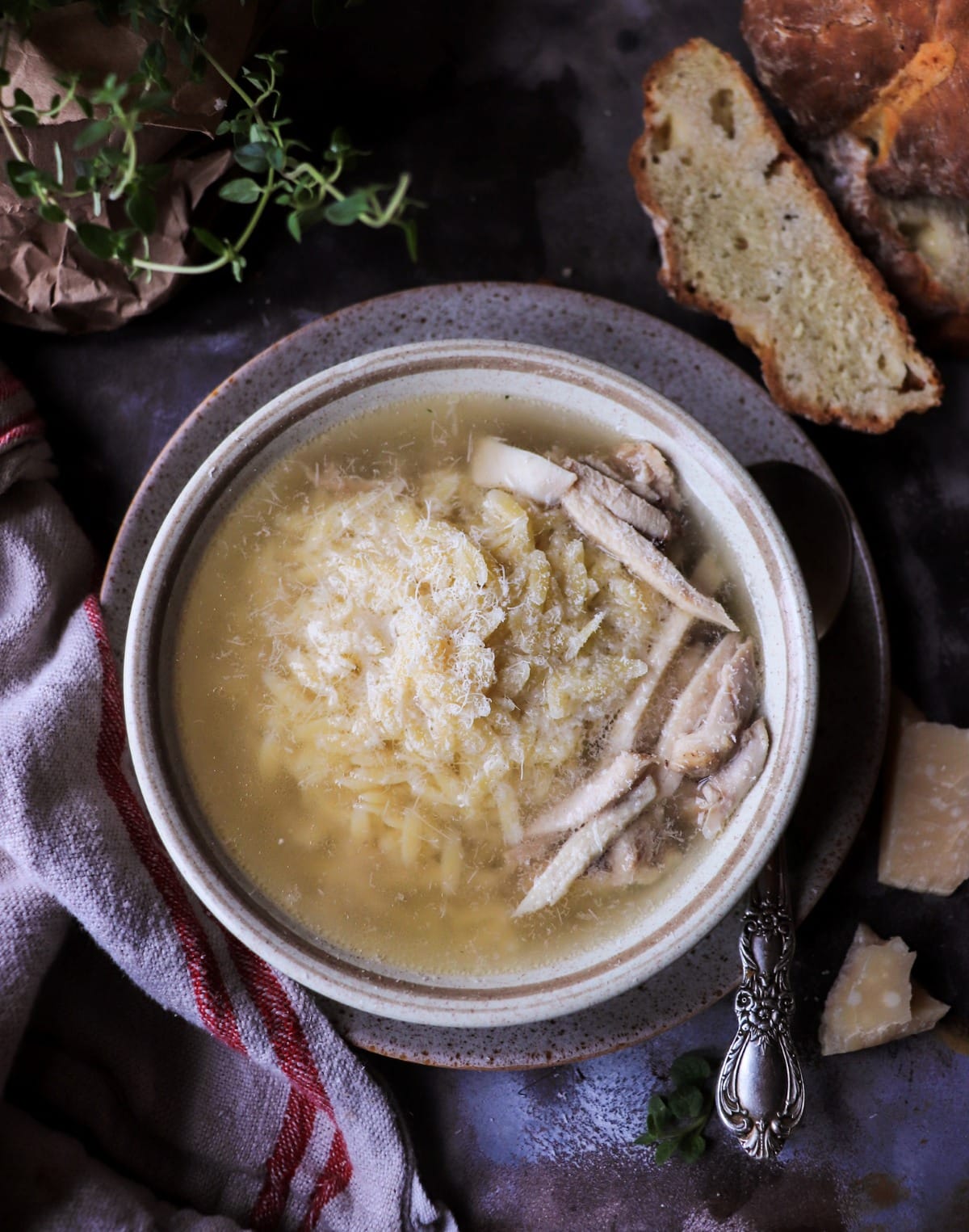 Italian Pastina Soup with orzo, shredded chicken, and finely grated Parmigiano in clear pale golden broth, served with rustic bread.