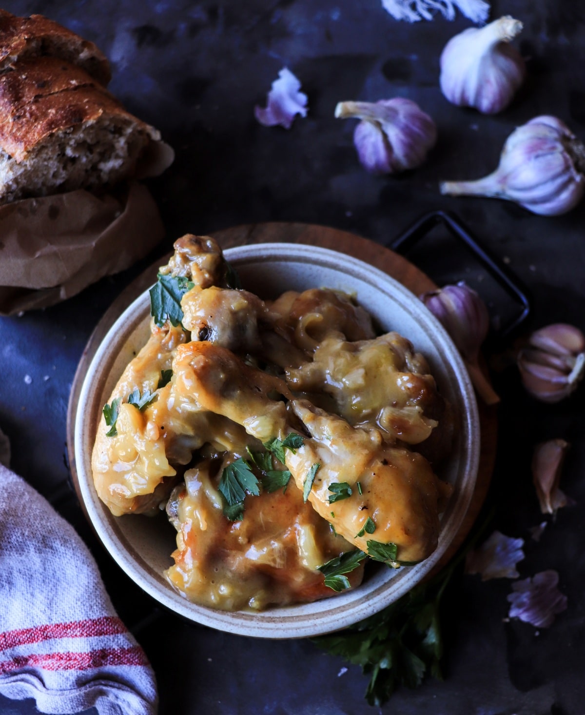 Overhead view of Pollo al Ajillo with tender chicken pieces in rich garlic and white wine sauce, garnished with fresh parsley.