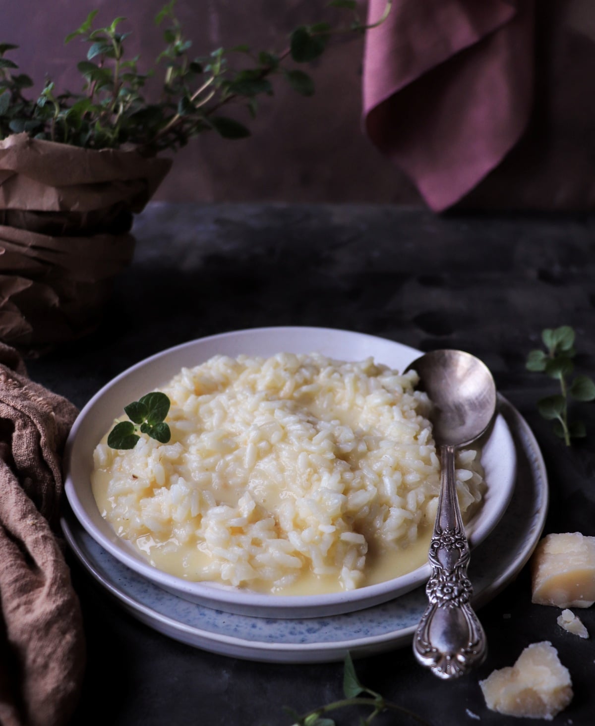 Creamy risotto al Parmigiano served on a flat plate, with glossy grains of rice in a light Parmesan-butter sauce.