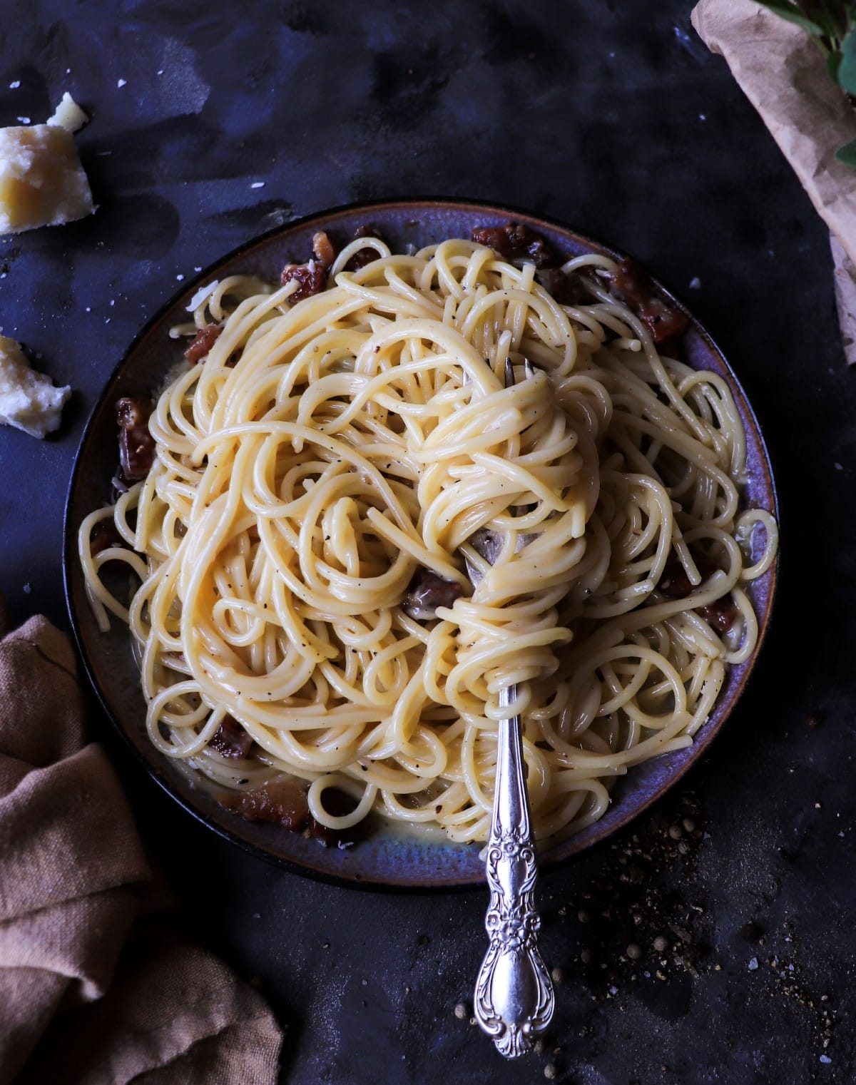 Classic spaghetti carbonara with glossy strands of pasta coated in a silky egg yolk and Pecorino Romano sauce, finished with black pepper.