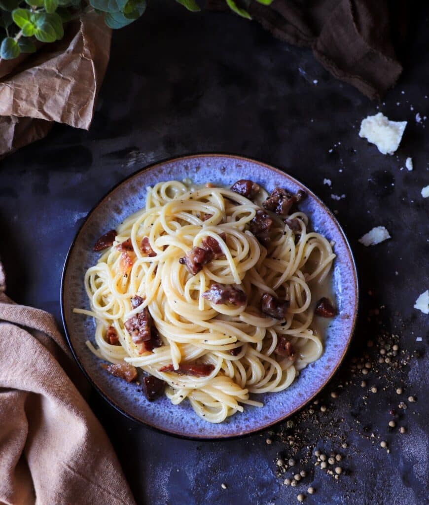Classic spaghetti carbonara with glossy strands of pasta coated in a silky egg yolk and Pecorino Romano sauce, finished with black pepper.