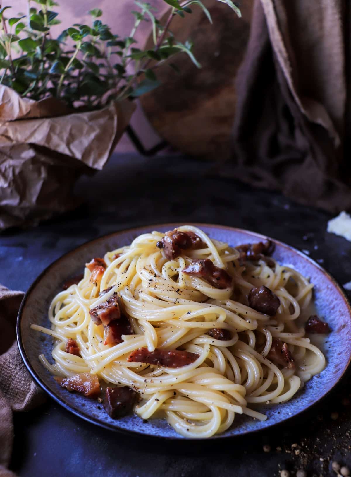 Plated spaghetti carbonara served in a shallow bowl, showing the creamy texture of the sauce and evenly coated pasta strands.