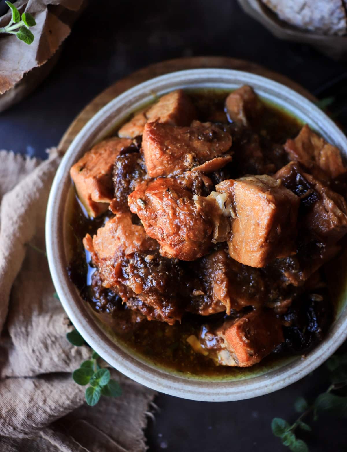 Spanish-Style Pork with Prunes (Cerdo con Ciruelas) in a rustic bowl with glossy white wine sauce and tender pork chunks.