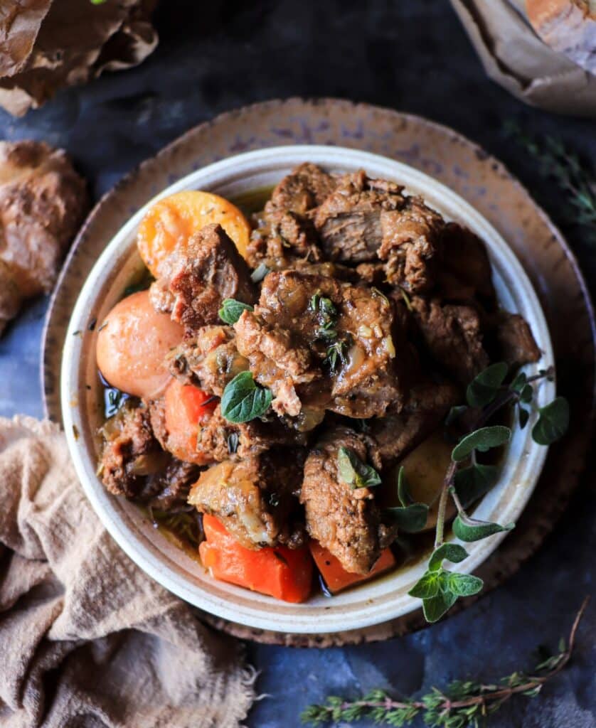 ALT: Close-up of traditional Irish Guinness beef stew with chunky beef, carrots, and whole baby potatoes in a rich broth.