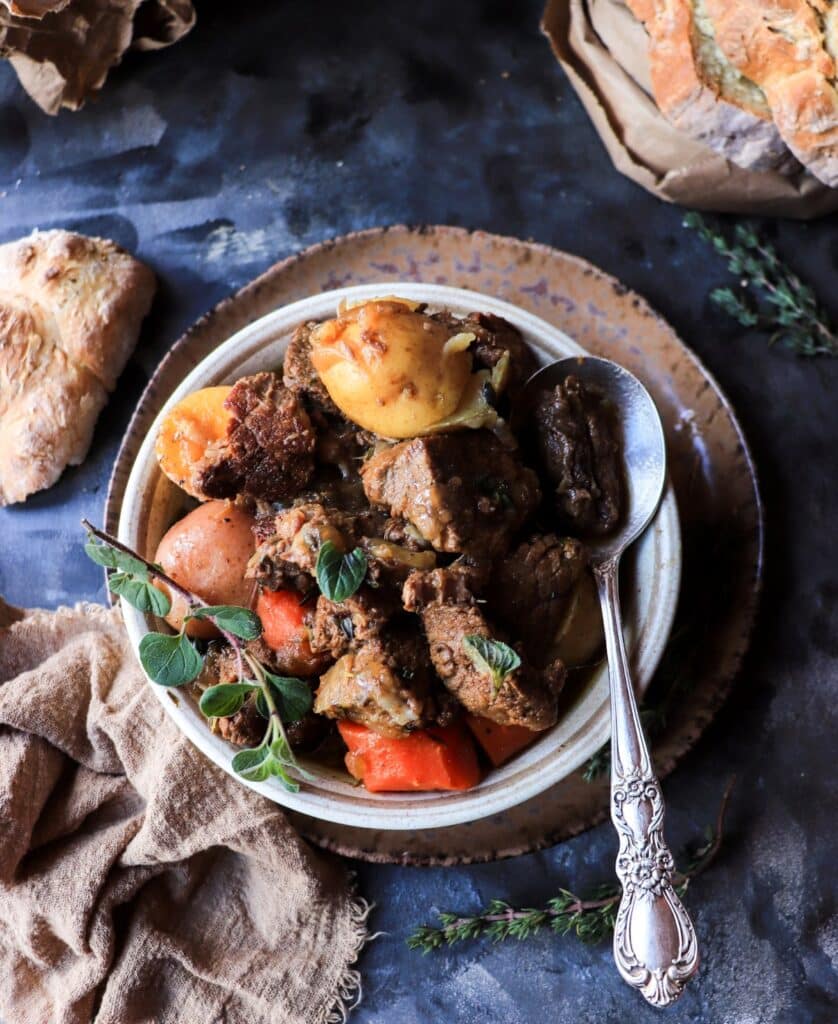 ALT: Close-up of traditional Irish Guinness beef stew with chunky beef, carrots, and whole baby potatoes in a rich broth.