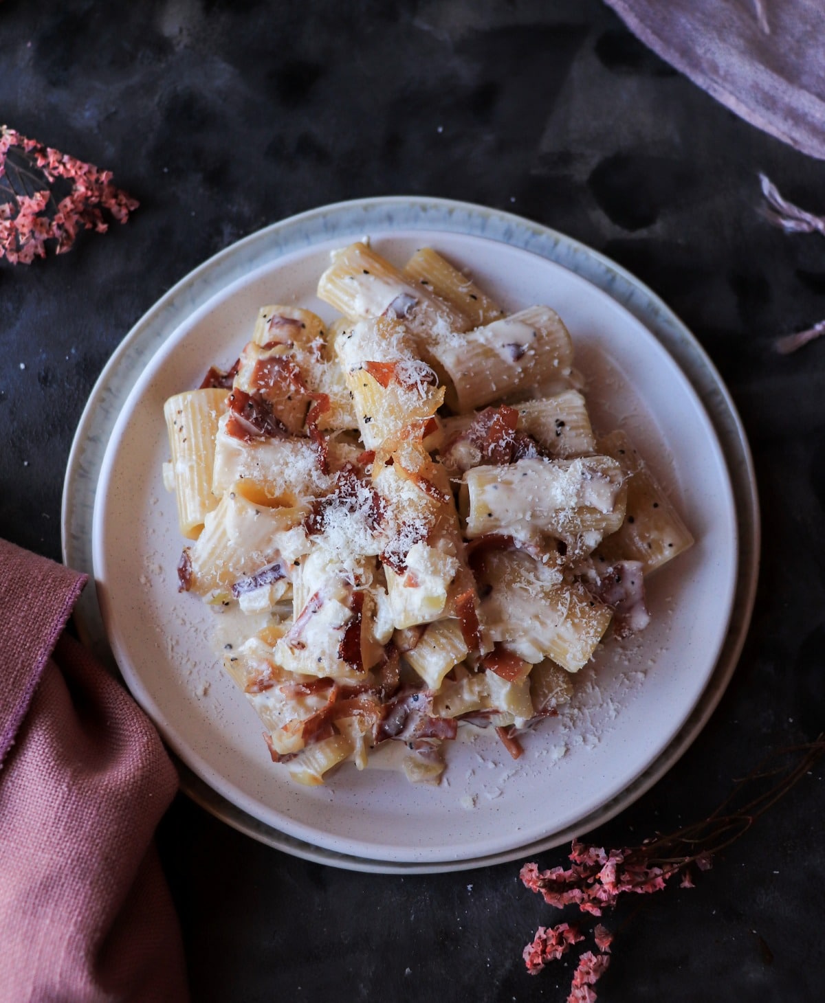 Creamy Speck Pasta with rigatoni, smoky speck, and a light sprinkle of Parmigiano, shown in an overhead view.