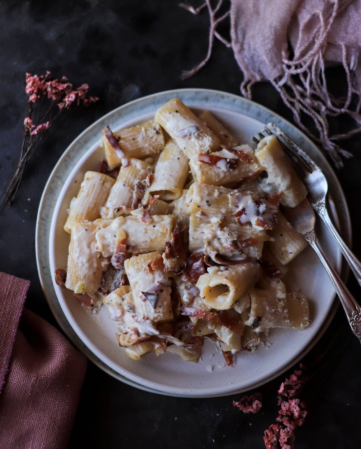 Creamy Speck Pasta with rigatoni, smoky speck, and a light sprinkle of Parmigiano, shown in an overhead view.