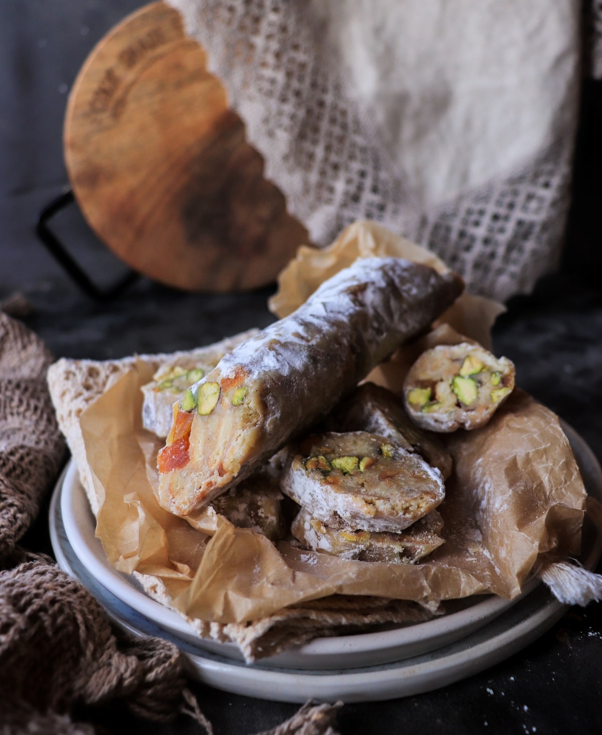 white chocolate salami with apricots and pistachios sliced on a plate