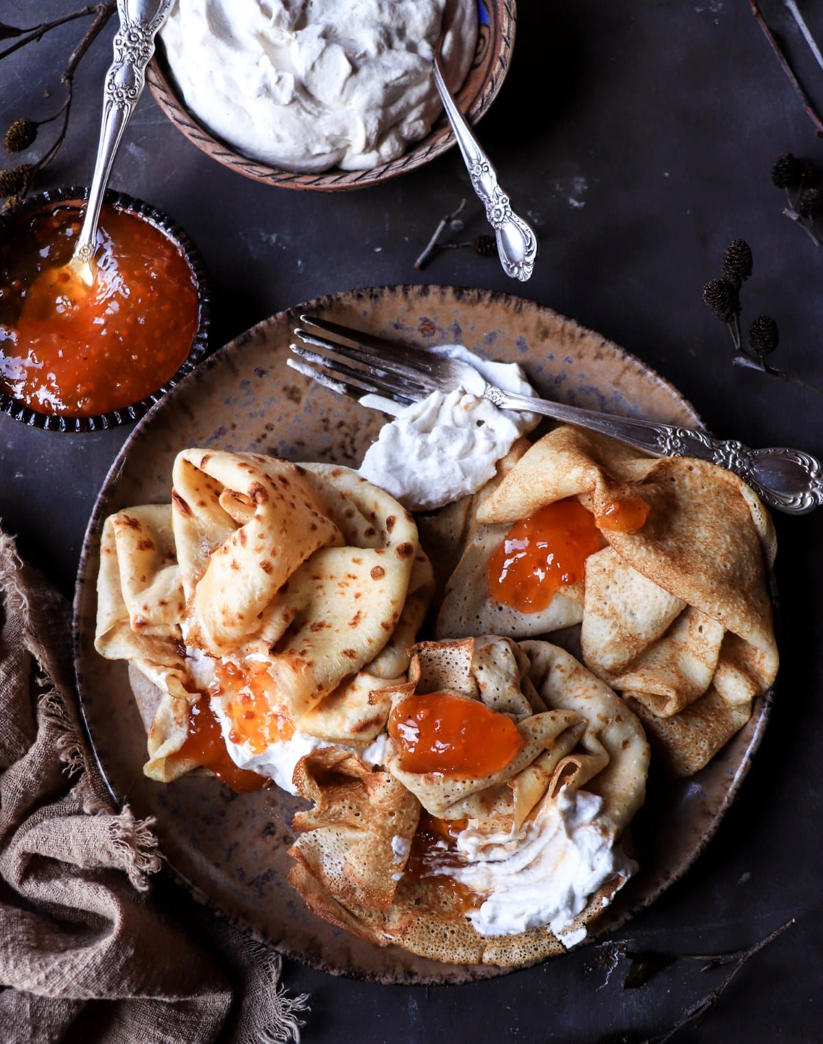 Crêpes with cloudberry jam and cardamom whipped cream served in a rustic Nordic style