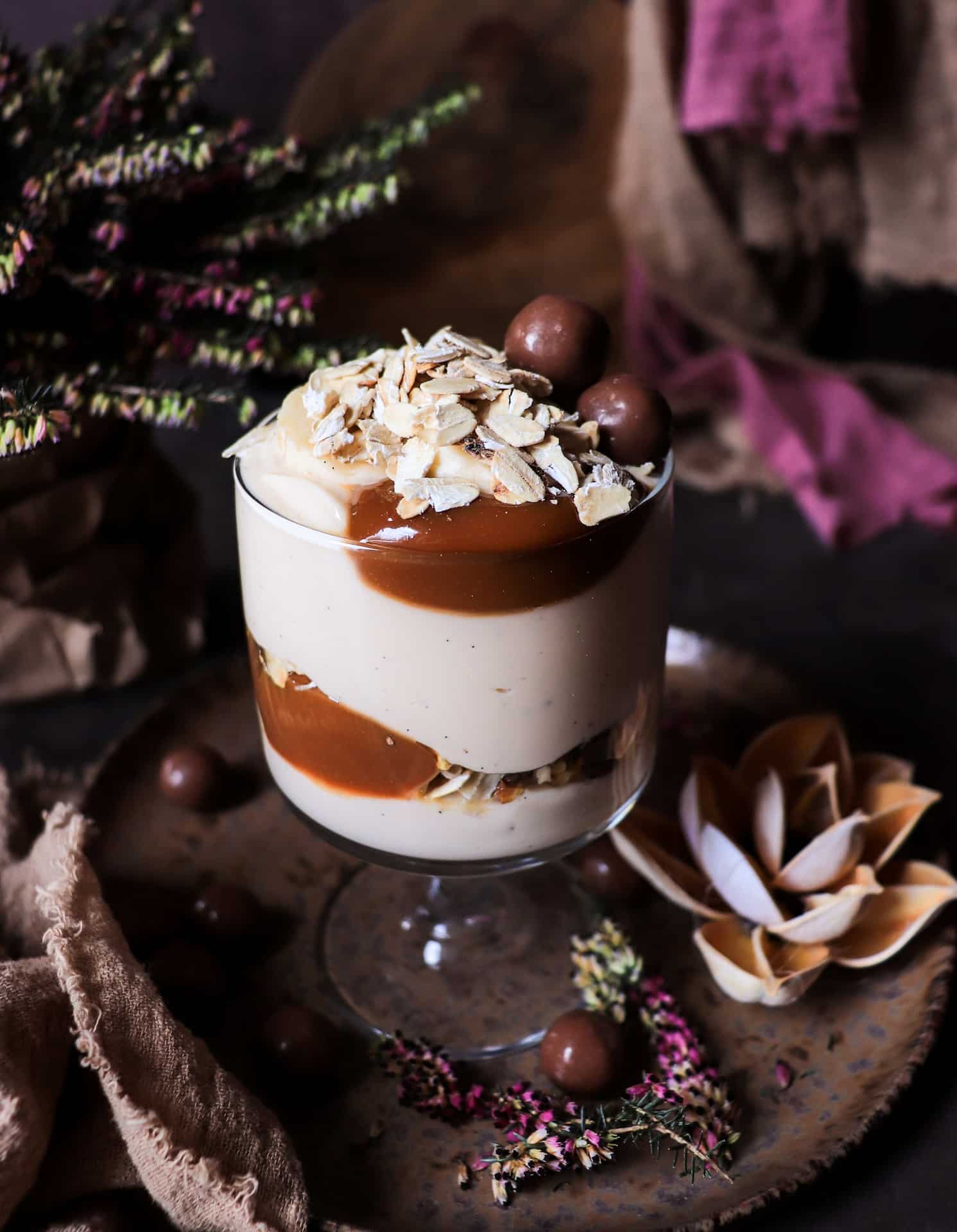 dulce de leche yogurt parfait with banana and toasted oats in a glass