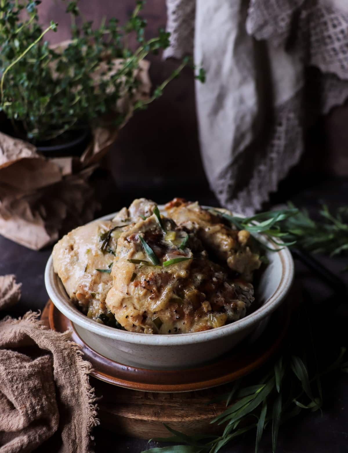 Poulet à l’Estragon served with rustic bread in a bowl with creamy tarragon sauce.