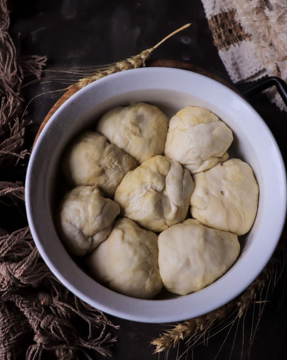 Shaped Pampushky dough arranged in a baking dish before baking.