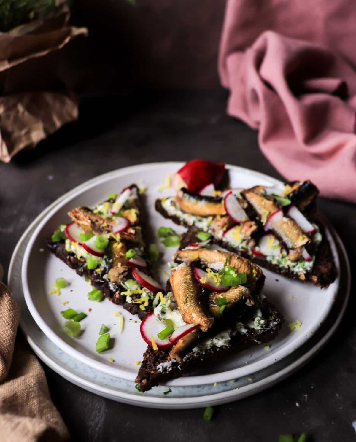 Buttered rye toast with smoked sprats, lemon zest, and radishes.