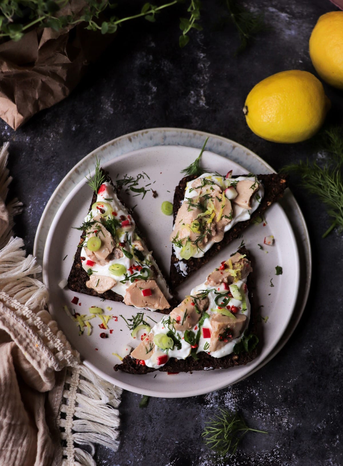 Cod liver canapé on rye bread with yogurt and herbs