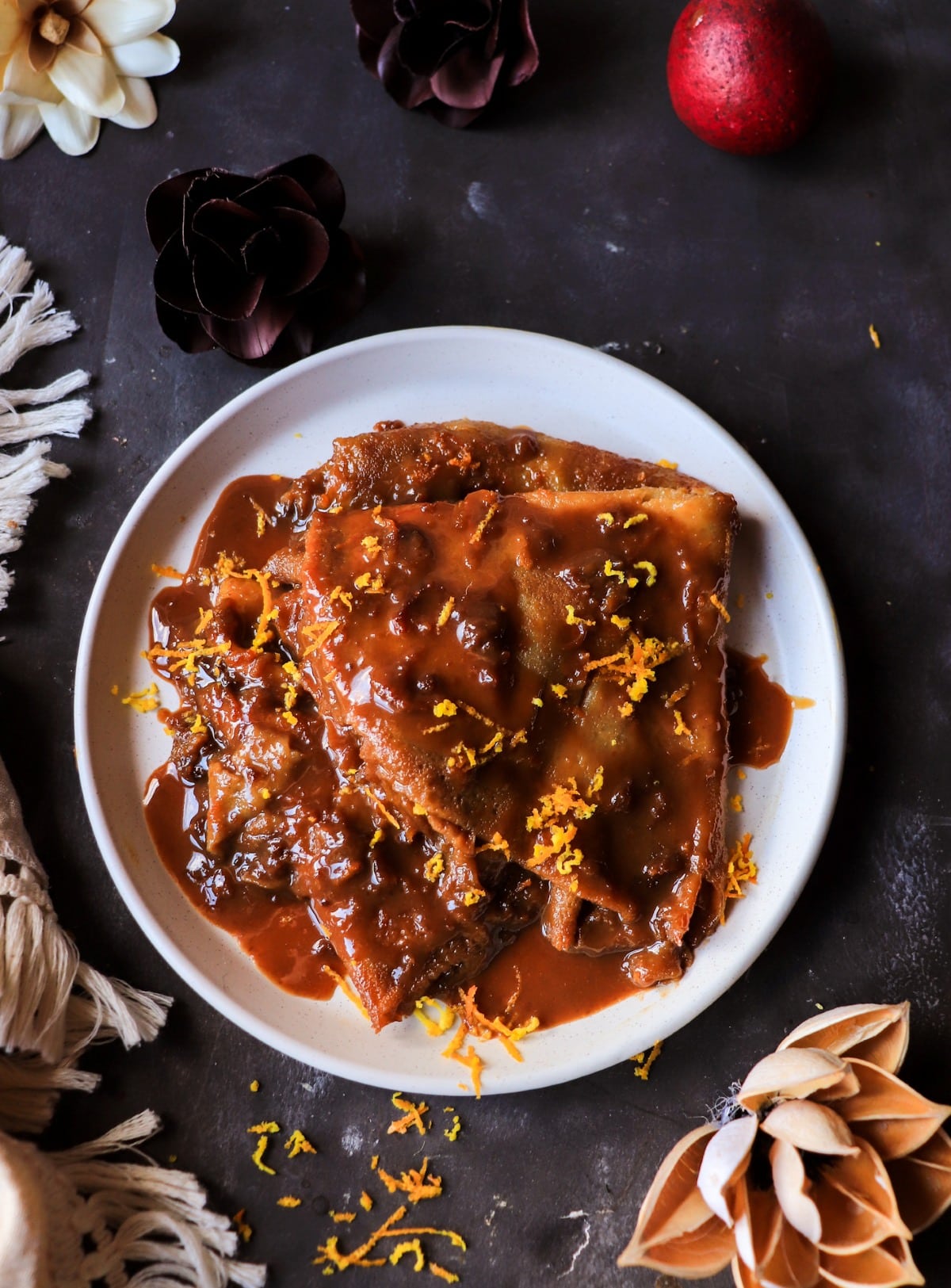 Dulce de Leche Crêpes Suzette with dark rum, orange zest, and caramelized sauce.
