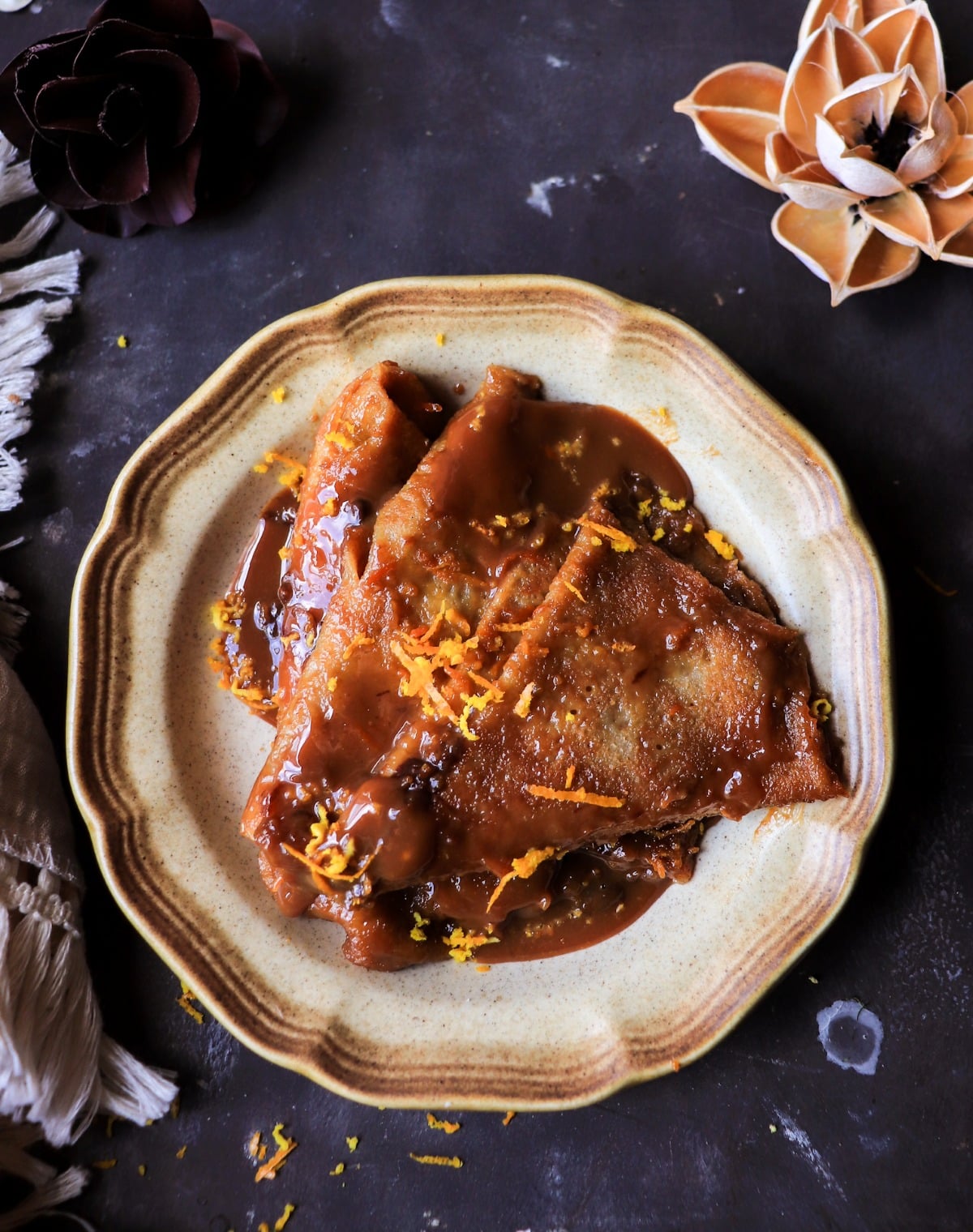 Folded Dulce de Leche Crêpes Suzette with orange and dark rum sauce.