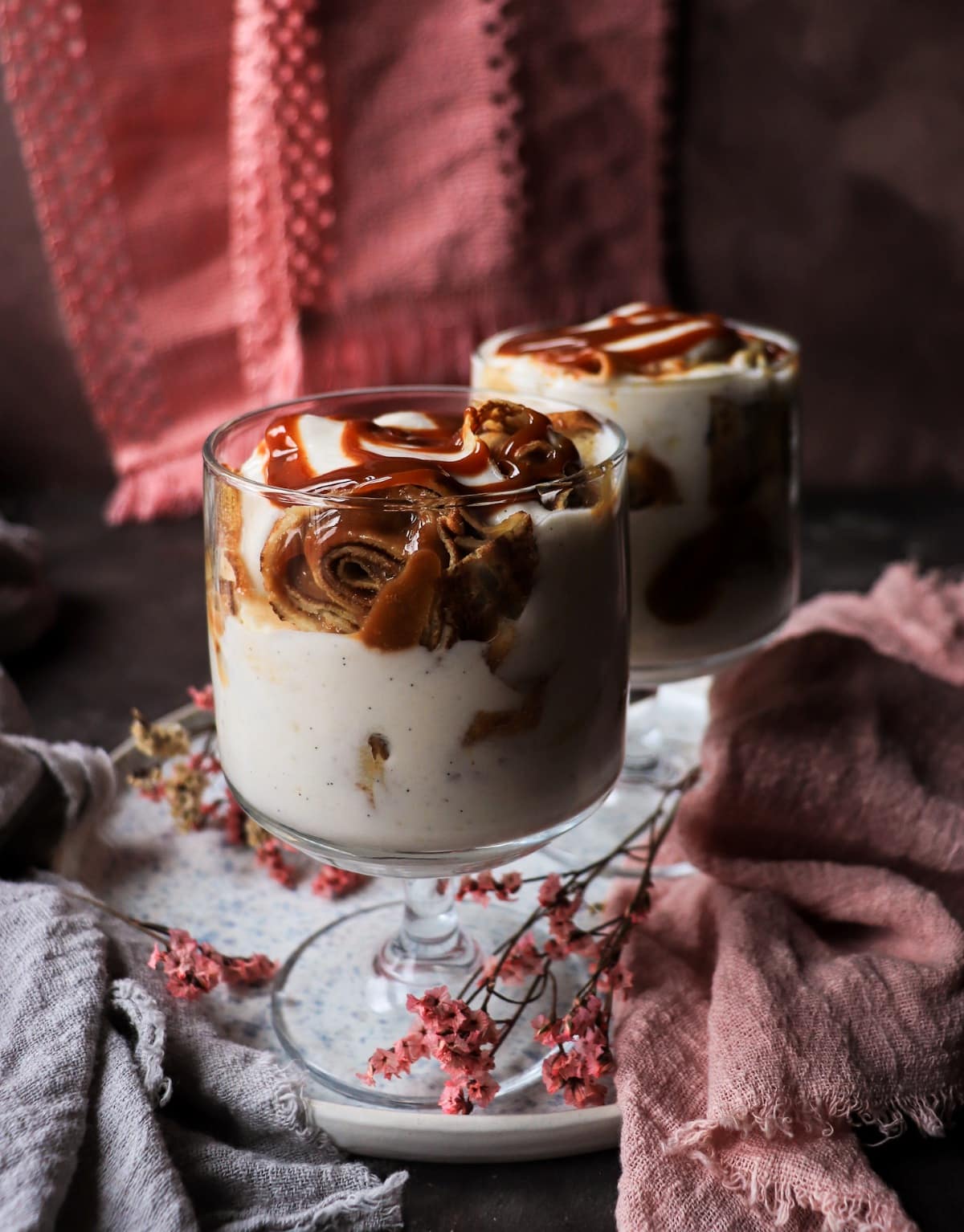 Dulce de leche trifle with crêpes, yogurt and banana in glasses.