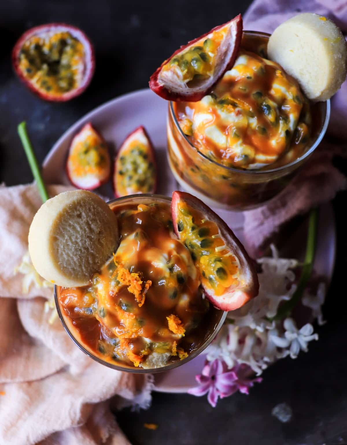 Passion fruit and dulce de leche dessert served in glasses with mascarpone cream and sable cookies.