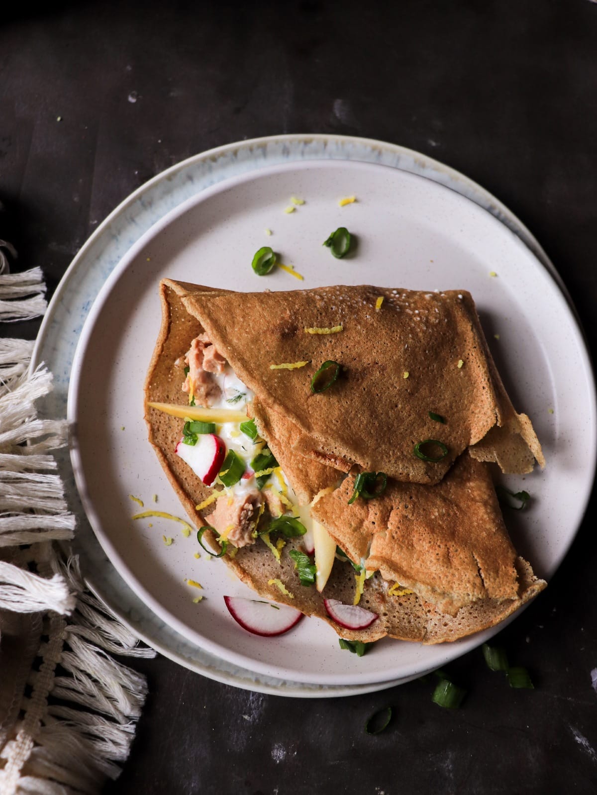 Rustic Nordic rye crêpes filled with cod liver, dill sauce, and radishes