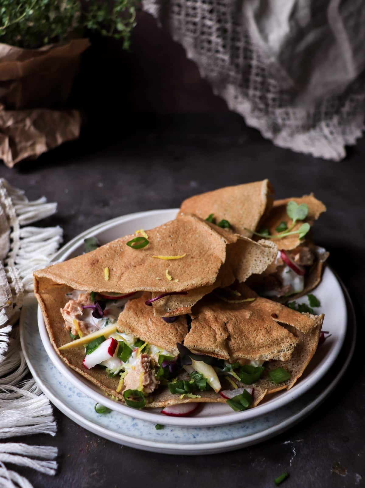 Nordic cod liver crêpe appetizer with yogurt sauce and green onions