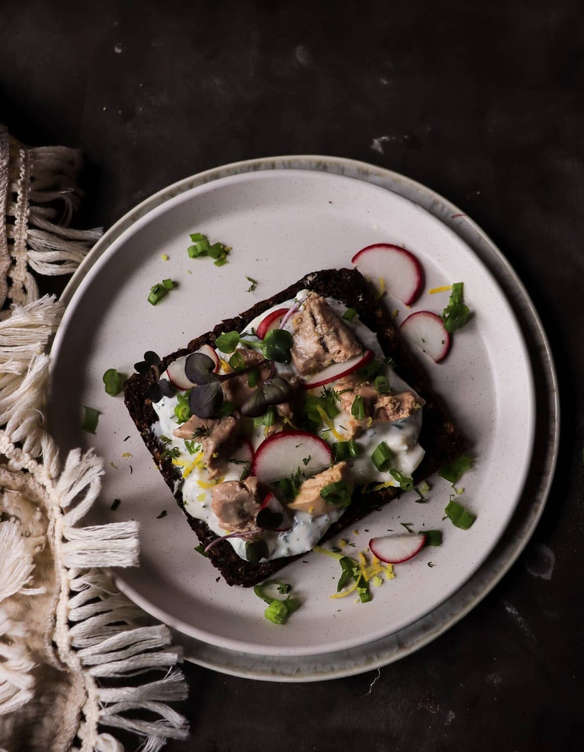 Rye toast with smoked cod liver, radishes, microgreens, and lemon zest