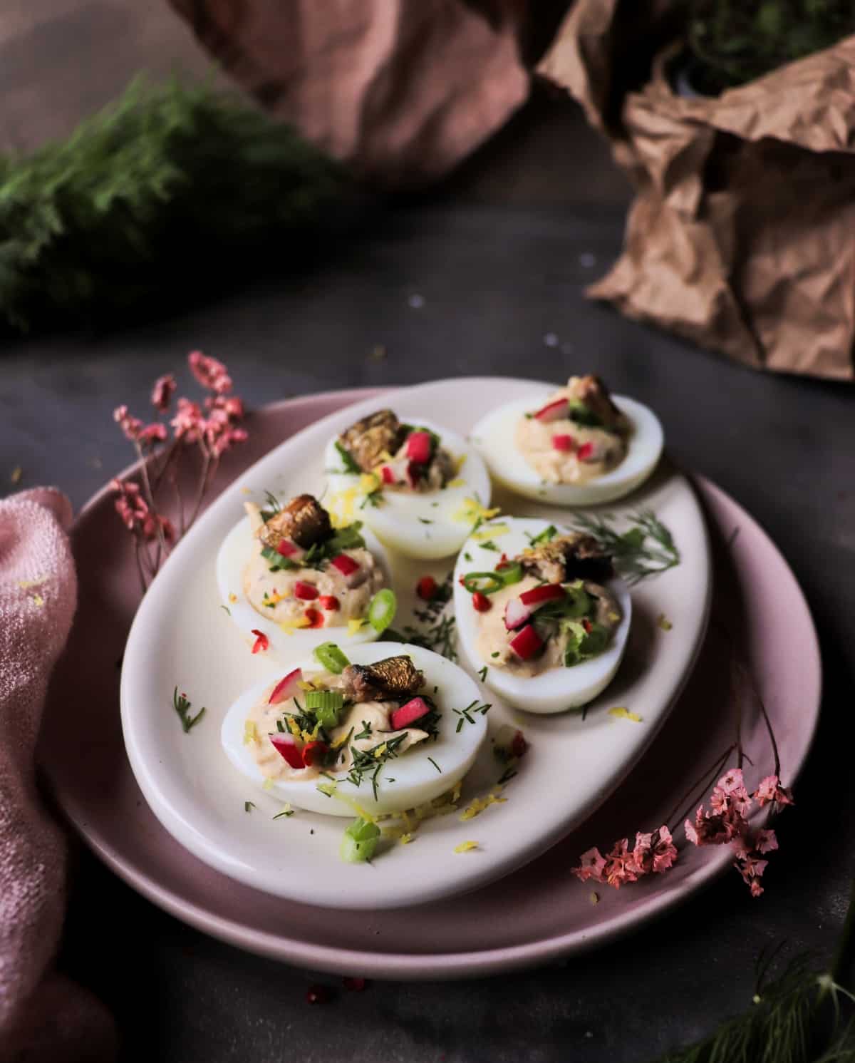 Smoked sprat deviled eggs topped with radishes, dill, and pink peppercorns.