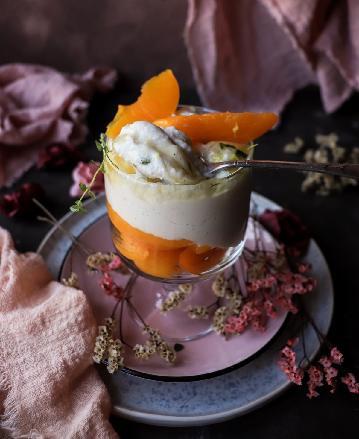 Honey ricotta dessert with canned peaches served in an individual glass.
