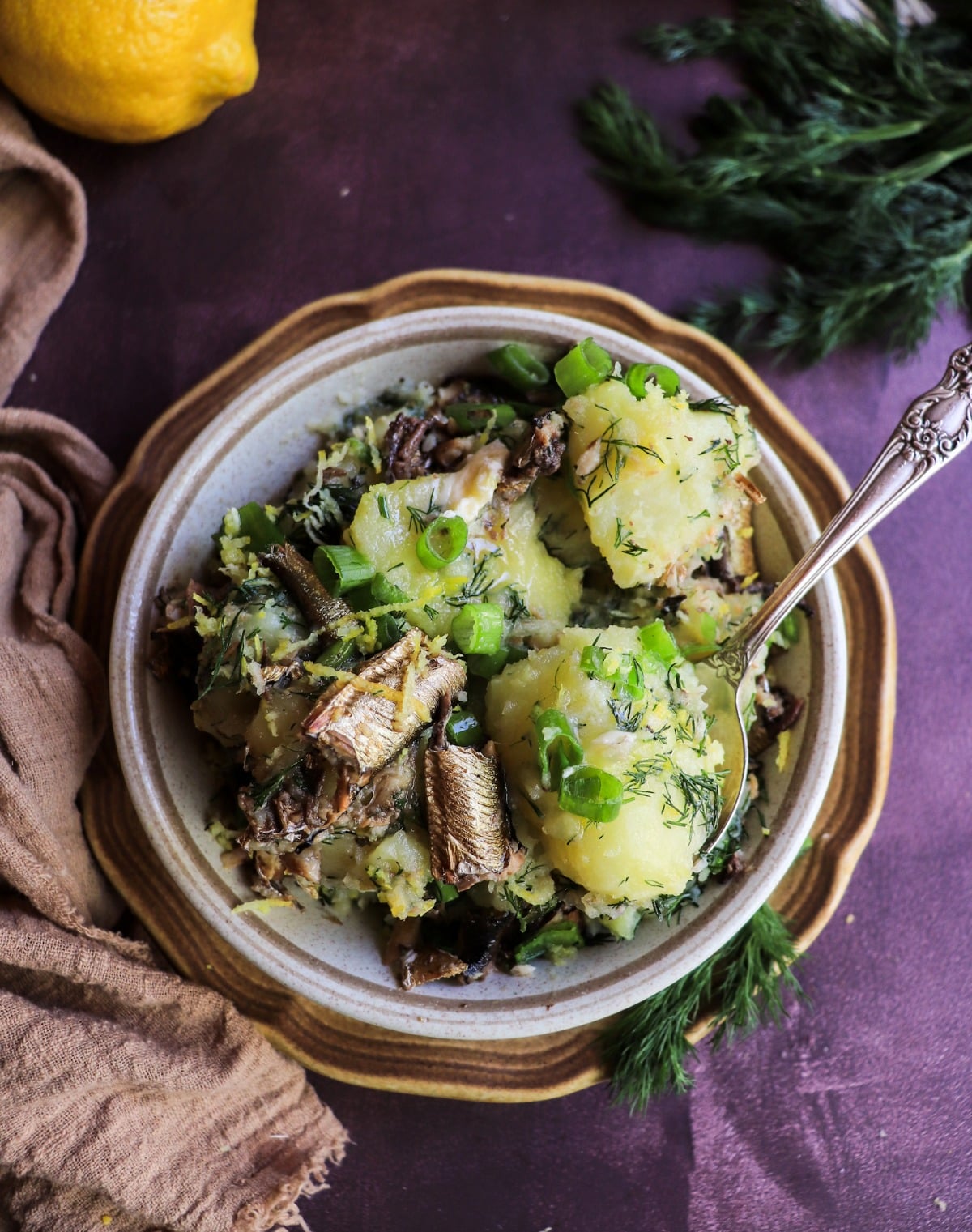 Rustic potatoes tossed with smoked sprats, dill, lemon, and green onions.