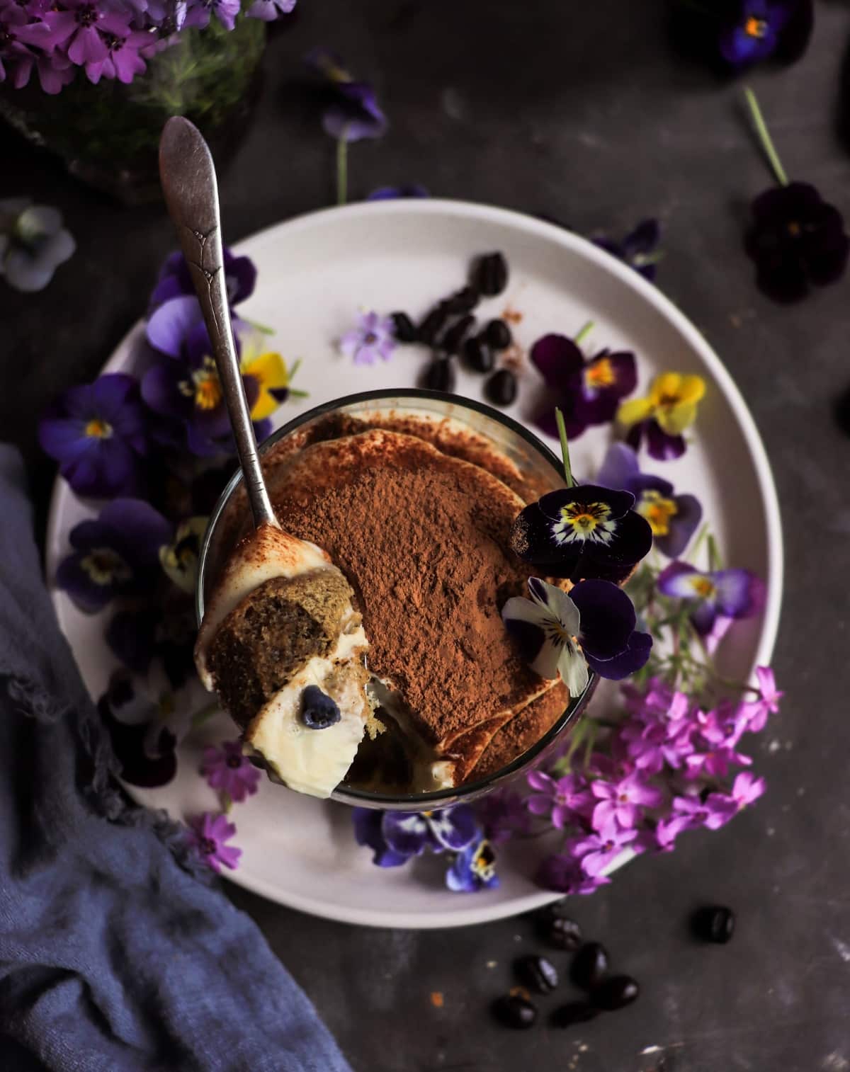Spoonful of violet tiramisu showing creamy mascarpone filling and coffee-soaked ladyfingers.