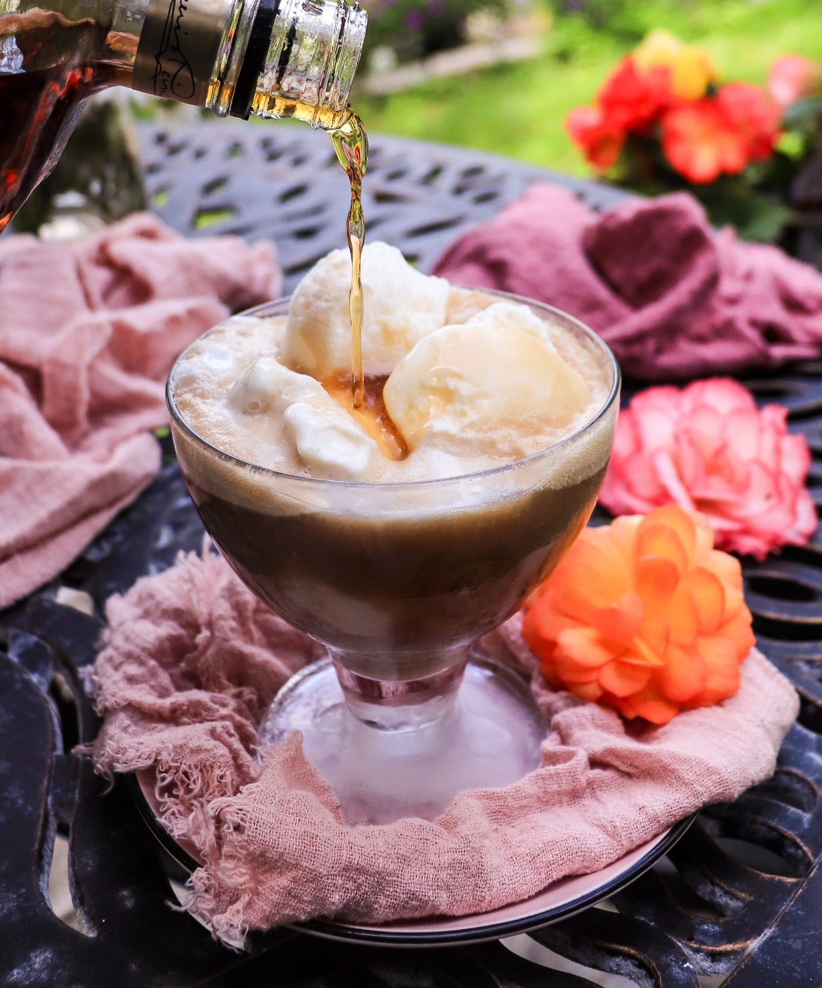 pouring amaretto into a root beer float with vanilla ice cream
