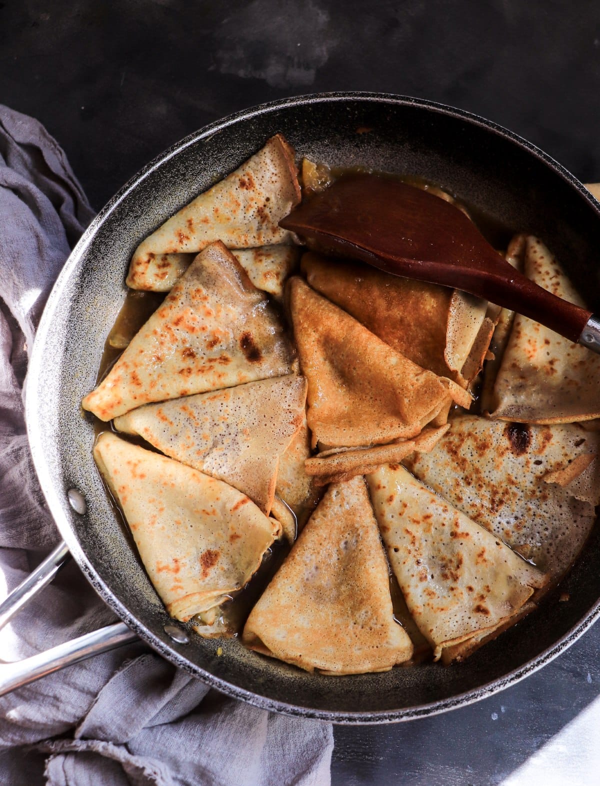 Crêpes Suzette cooking in honey-lemon butter sauce before