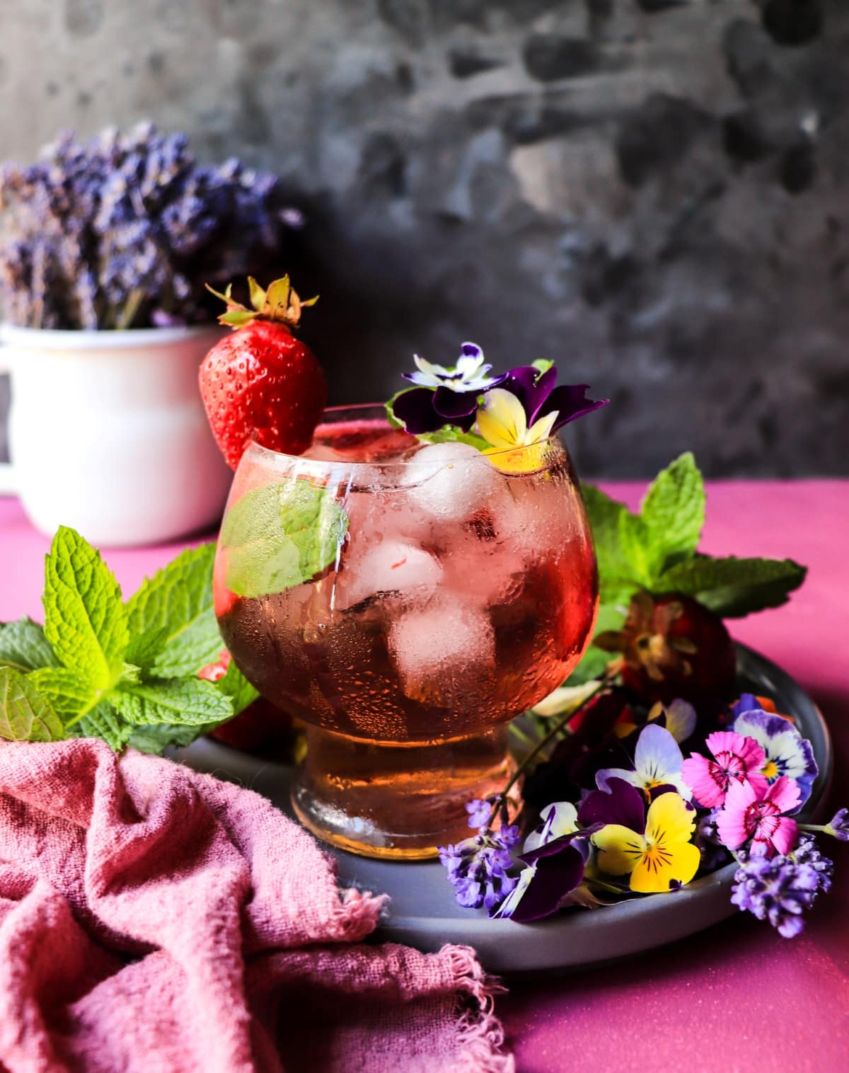 Fresh strawberry sangria with rosé, mint, ice, and violet flower garnish