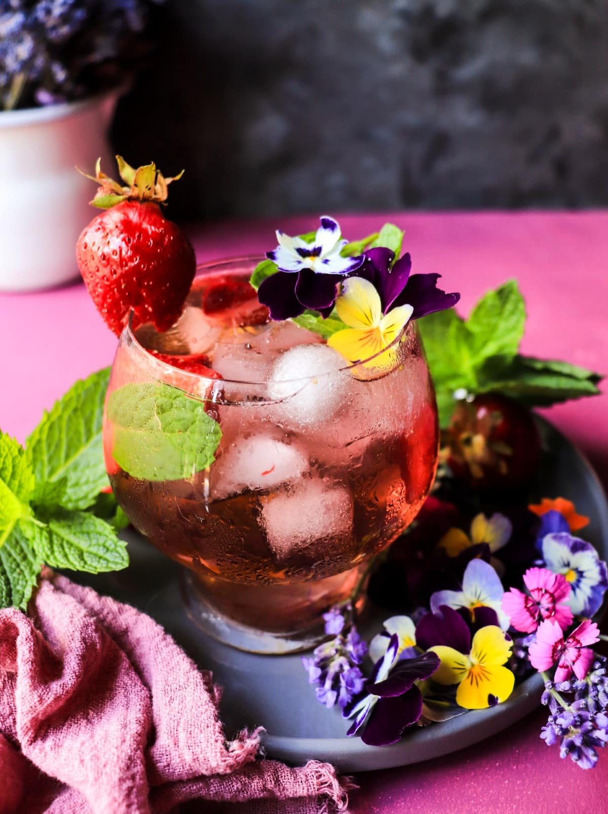 Strawberry Violet Sangria with rosé, fresh strawberries, mint, and violet flowers